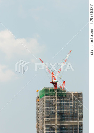 Crane at condominium construction site 129586327