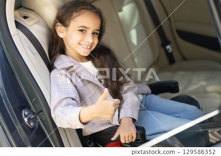Sweet girl of school age in the car drawing and looking peaceful 129586352