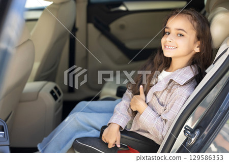 Sweet girl of school age in the car drawing and looking peaceful Sweet girl of school age in the car drawing and looking peaceful 129586353