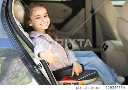 Sweet girl of school age in the car drawing and looking peaceful 129586354