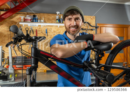 Bearded bike repair specialist working in organized workshop Bearded bike repair specialist working in organized workshop 129586366