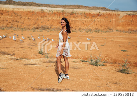 brunette in white summer dress in the desert brunette in white summer dress in the desert 129586818