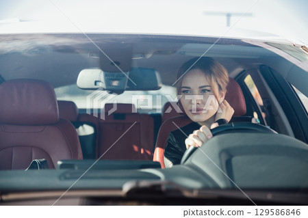 Woman Driving A Car On The Road Looking In The Mirror Woman Driving A Car On The Road Looking In The Mirror 129586846