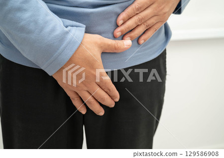 Hernia, Asian man stomach ache, abdominal pain and urology problem health. 129586908