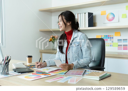 Creative Designer Analyzing Color Palettes in Modern Workspace 129589659