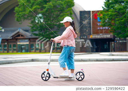 Asian girl is going to ride a scooter. Copy space Asian girl is going to ride a scooter. Copy space 129590422