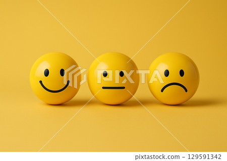 Brightly yellow colored smiley spheres closely grouped to showcase joy and solidarity in embracing diversity, inclusion, equity and feedback. 129591342