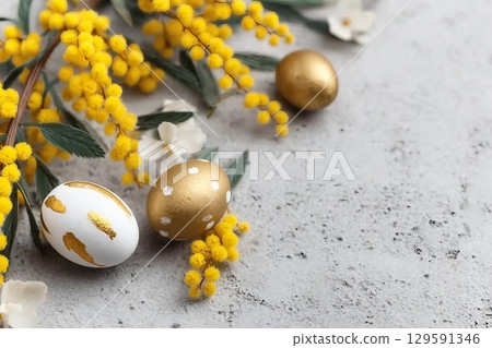 Mimosa branch, Easter eggs on gray concrete background. Beautiful Easter spring background with place for text. 129591346