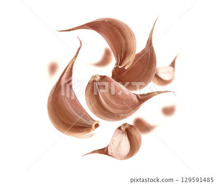 Garlic cloves levitate on a white background 129591485