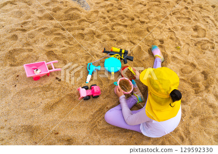 Asian girl play toys in the beach. The concept of holiday activities. 129592330
