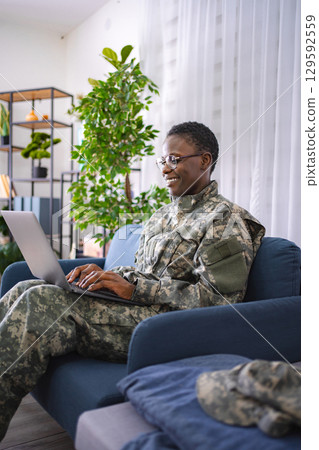 Military Professional Working on Laptop in Home Setting Military Professional Working on Laptop in Home Setting 129592559