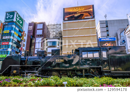 Tokyo cityscape, Japan, August 8th. A view of the steam locomotive and bar district in front of Shimbashi SL Square in Shimbashi, under a clear summer sky. 129594178