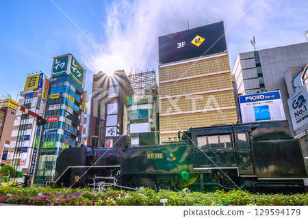 8月8日，日本東京城市景觀。晴朗的夏日天空下，新橋新橋SL廣場前的蒸氣機車和酒吧區。 129594179