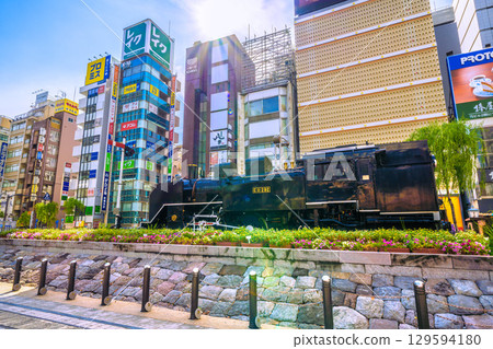 8月8日，日本東京城市景觀。晴朗的夏日天空下，新橋新橋SL廣場前的蒸氣機車和酒吧區。 129594180