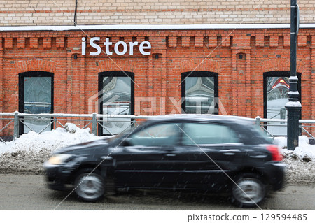 Orenburg, Russia - January 16, 2025 iStore on a snowy, slushy street: a contrast between technology and winter weather. Editorial 129594485