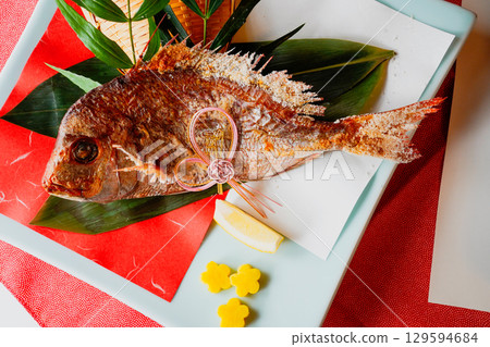 Grilled sea bream and celebratory decorations Grilled sea bream and celebratory decorations 129594684