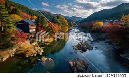 The river reflects the autumn leaves, creating a golden scene. 129594965