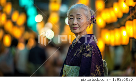 A woman walks through the night festival in a traditional kimono 129595050