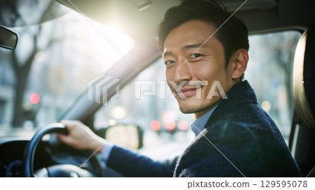 A man in a suit drives an SUV and looks back 129595078