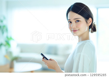 微笑的女人拿著智慧型手機 129595285