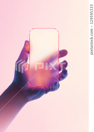 Hand holding smartphone with futuristic liquid glass design and smooth reflection, set on hazy pink background. 129595333