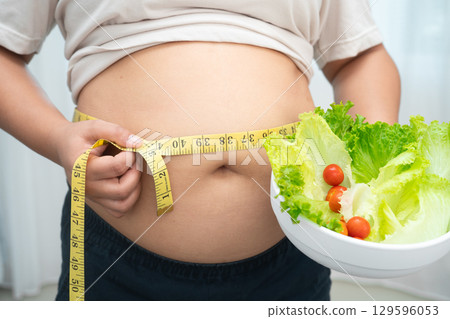 Asian woman with fat belly big size overweight and obesity with healthy food. 129596053