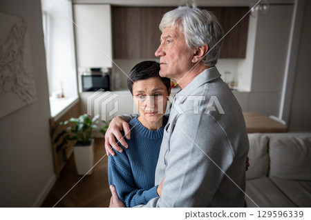 Wife comforting worried husband. Elderly frightened couple hugging supporting each other with love 129596339