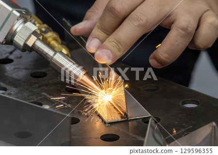 Close up scene the laser welding process by hand held laser welding machine. Close up scene the laser welding process by hand held laser welding machine. 129596355