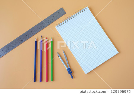 Study desk with notebooks and colored pencils . 129596975