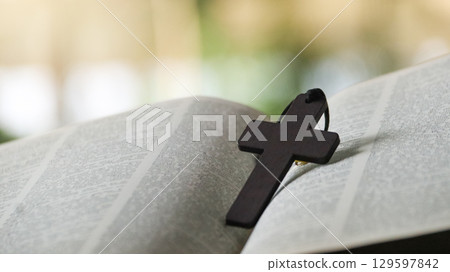 Wooden Jesus Cross on Old Book 129597842