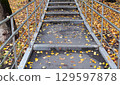 Autumn leaves on steps of city staircase on cloudy, rainy day 129597878