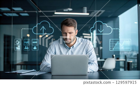 focused businessman in modern office, working intently on laptop 129597915