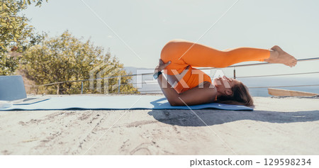 Woman Practicing Yoga on a Rooftop with Ocean View 129598234