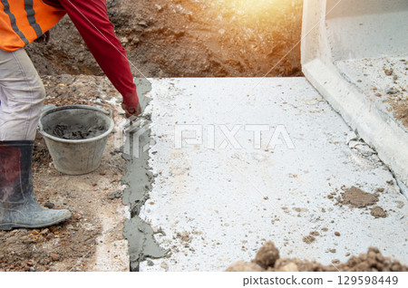Workers are plastering the construction area. 129598449