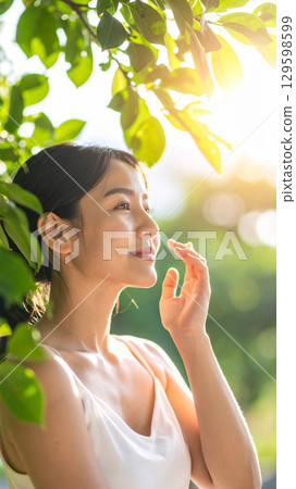 Sunlight filtering through the trees and a smiling woman's profile 1 129598599