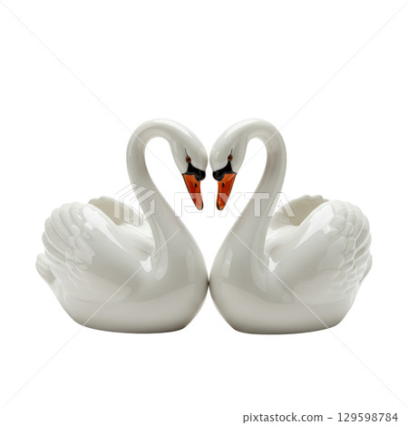 Two white porcelain swan figurines forming a heart shape as a symbol of love and romance 129598784