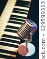 vintage condenser microphone on piano keys 129599313