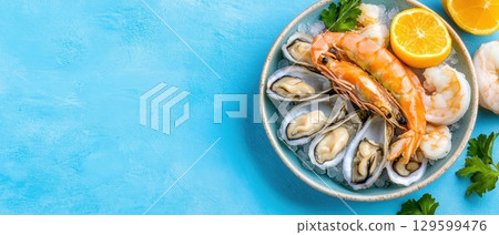 Fresh seafood platter with shrimps, oysters, and lemon slices on ice. Horizontal banner with copy space for text, poster, free space 129599476