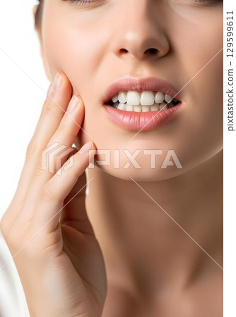 Young woman touching cheek with hand showing toothache facial discomfort and dental pain on white background Young woman touching cheek with hand showing toothache facial discomfort and dental pain on white background 129599611