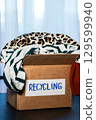 Box of used clothing marked for recycling. Eco friendly lifestyle. Closet management. 129599940