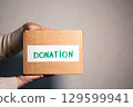 Woman preparing old clothes for charity. Clothes donation concept. Second hand shop. 129599941