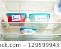 Handwritten names on reusable food containers in work fridge. Image for eco friendly office initiatives. 129599943