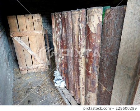 Rustic Barn Interior Showcasing Wooden Panels in a Village Setting During Daylight Hours 129600289