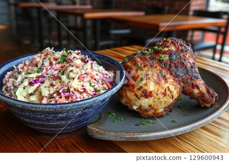 Crispy Southern Fried Chicken Plate with Creamy Coleslaw on a Rustic Restaurant Table Setting 129600943