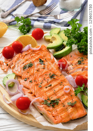 grilled salmon fillet on circle wooden board 129601780