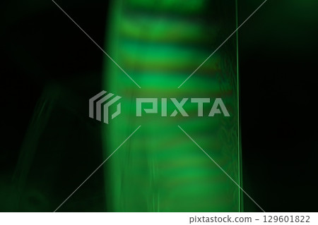 Green liquid film, fantastic bubbles connections, fluid movement, dark fantastic background, transparent oil, green ink 129601822