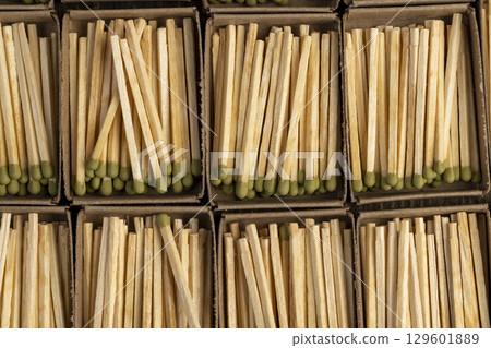 wooden matches with head in matchbox, the green head of a wooden match laid out in cardboard boxes, closeup, top view wooden matches with head in matchbox, the green head of a wooden match laid out in cardboard boxes, closeup, top view 129601889