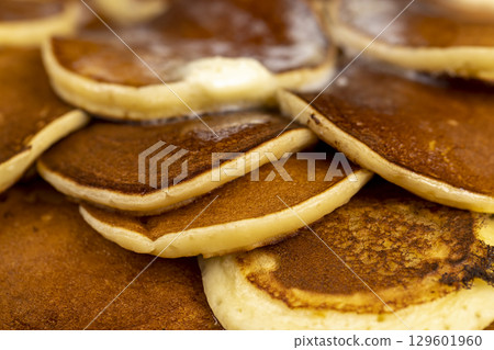 pancakes with butter that melts closeup, a large pile of round pancakes with butter made from milk after cooking 129601960