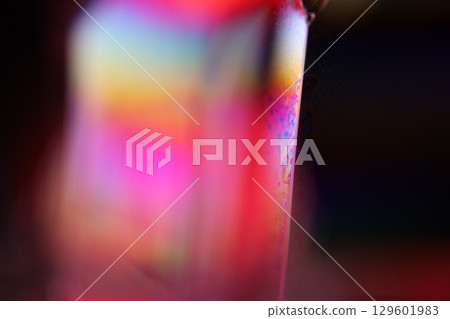 Bright multicoloured liquid surface on black background, interference pattern Bright multicoloured liquid surface on black background, interference pattern 129601983