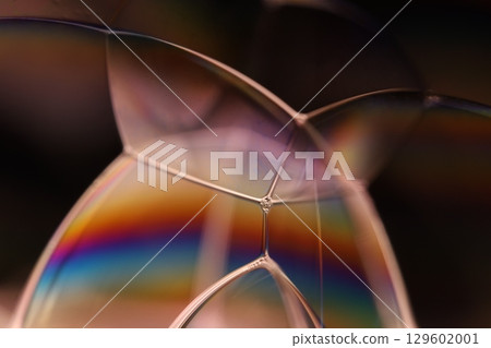 Bright multicoloured liquid surface on black background, interference pattern 129602001